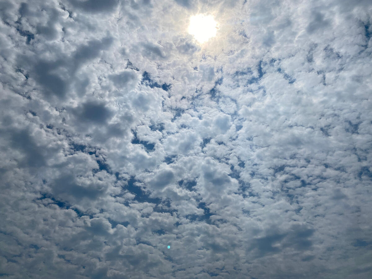 Sun Through the Clouds The sun shining through a large clump of clouds.
